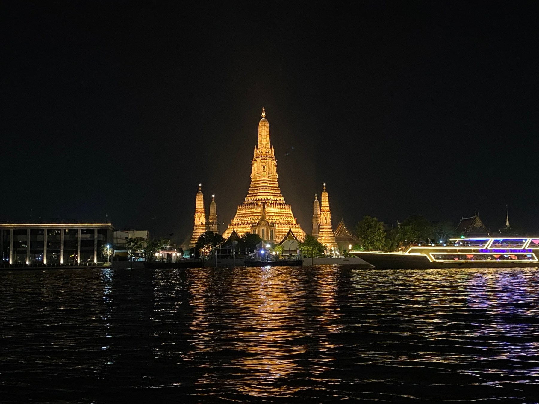 Wat Arun illuminated across the Chao Phraya River in Bangkok